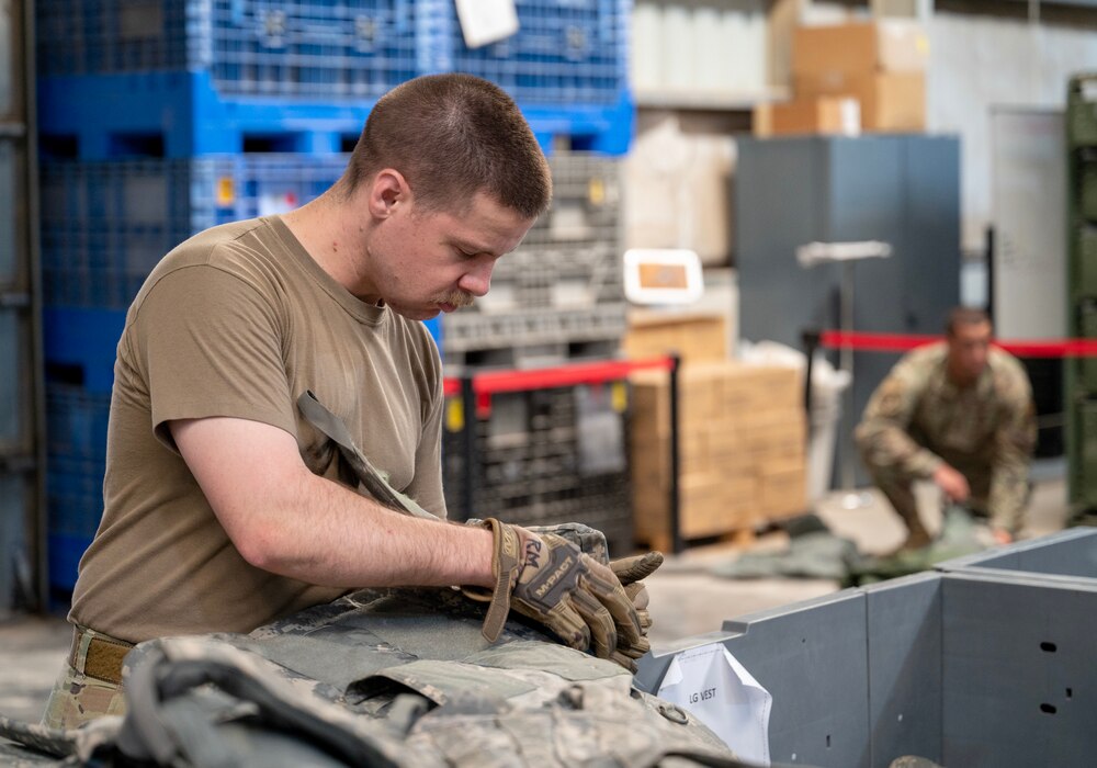 A photo of an Airman working on a plate carrier.