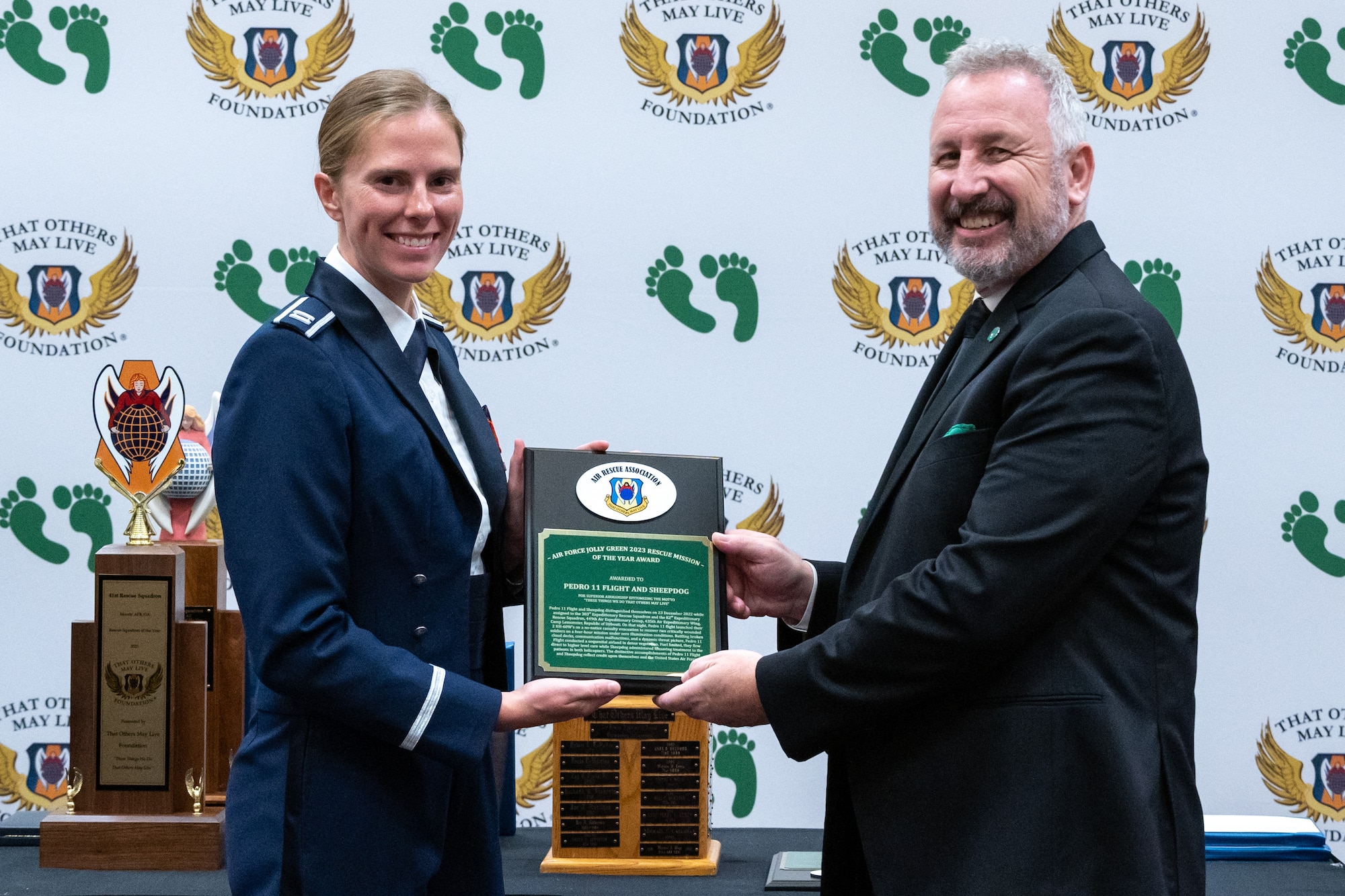 Chris Barnett, right, president of the Air Rescue Association, presents the 2023 Jolly Green Association Mission of the Year award to U.S. Air Force Capt. Abby Norwood from the 41st Rescue Squadron at the 2023 Air Rescue Awards Gala in Las Vegas, Nevada, Sept. 23, 2023. Capt. Norwood accepted the award on behalf of Pedro 11 Flight and Sheepdog assigned to the 38th Rescue Squadron, 347th Rescue Group, from the 23rd Wing, Moody Air Force Base, Georgia. Pedro 11 Flight and the pararescue team, call sign, Sheepdog, distinguished themselves during their assignment to Camp Lemonnier, Republic of Djibouti. During extreme and unfortunate circumstances, Pedro 11 Flight conducted a sequential airland in dense vegetation with limited fuel while Sheepdog administered lifesaving treatment to patients in both helicopters. (U.S. Air Force photo by Airman 1st Class Elizabeth Tan)