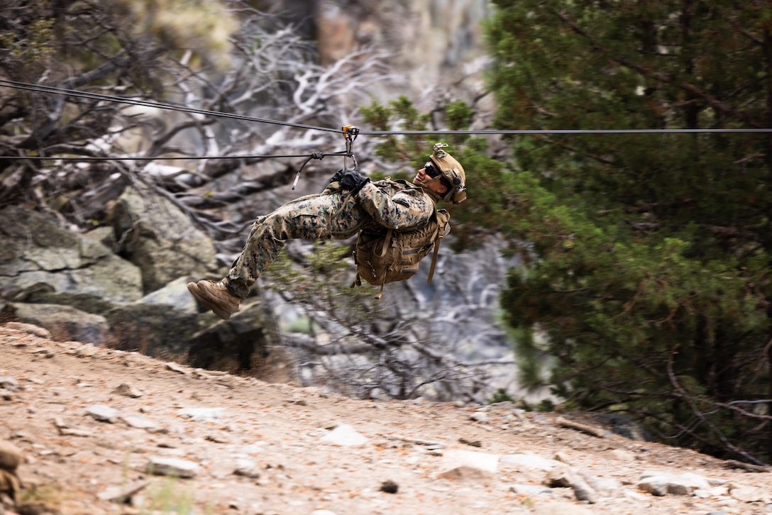 A U.S. Marine with 1st Battalion, 1st Marine Regiment, 1st Marine Division, uses a zipline to cross a canyon during Mountain Training Exercise 5-23 at Marine Corps Mountain Warfare Training Center Bridgeport, California, Aug. 18, 2023. MTX gives Marines the opportunity to hone their combat and survival skills in an austere mountain environment.