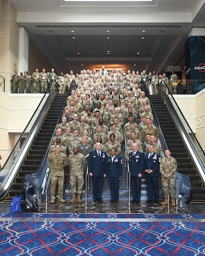 A large group of people in Air Force uniforms stand together for a photo.