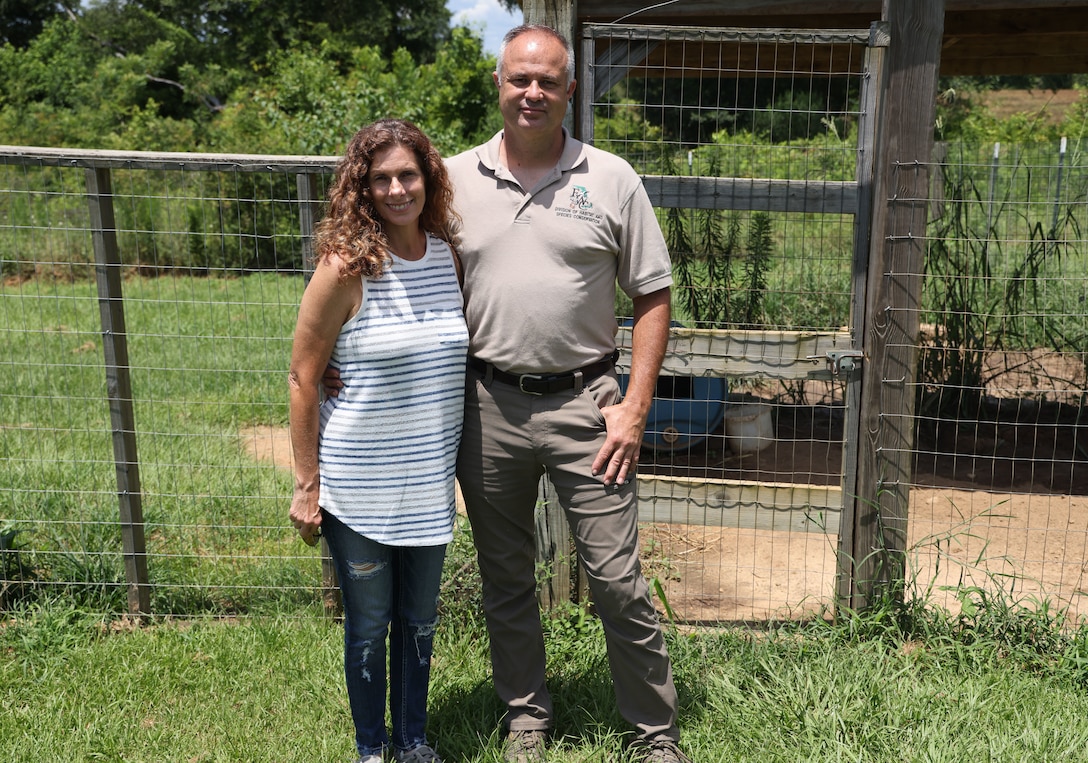 Kelly Bunting and her husband Nate, pose in their yard where five years earlier they rode out Hurricane Michael, in Sneads, Florida, August 7, 2023. Kelly, who worked as a ranger at the Lake Seminole Project Office at the time and their family rode out the storm in husband Nate’s bulldozer. (U.S. Army photo by Chuck Walker)