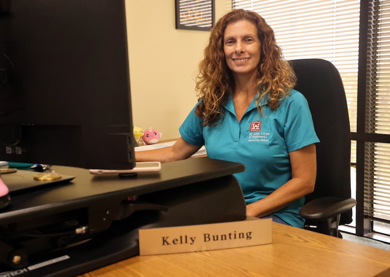 Kelly Bunting, a Project Manager with the U.S. Army Corps of Engineers, Jacksonville District Regulatory Division poses for a photo at her desk in Panama City, Florida, August 7, 2023. Bunting, who worked as a Park Ranger for the Lake Seminole Project Office at the time, and her family, rode out Hurricane Michael in 2018 in a bulldozer. (U.S. Army photo by Chuck Walker)