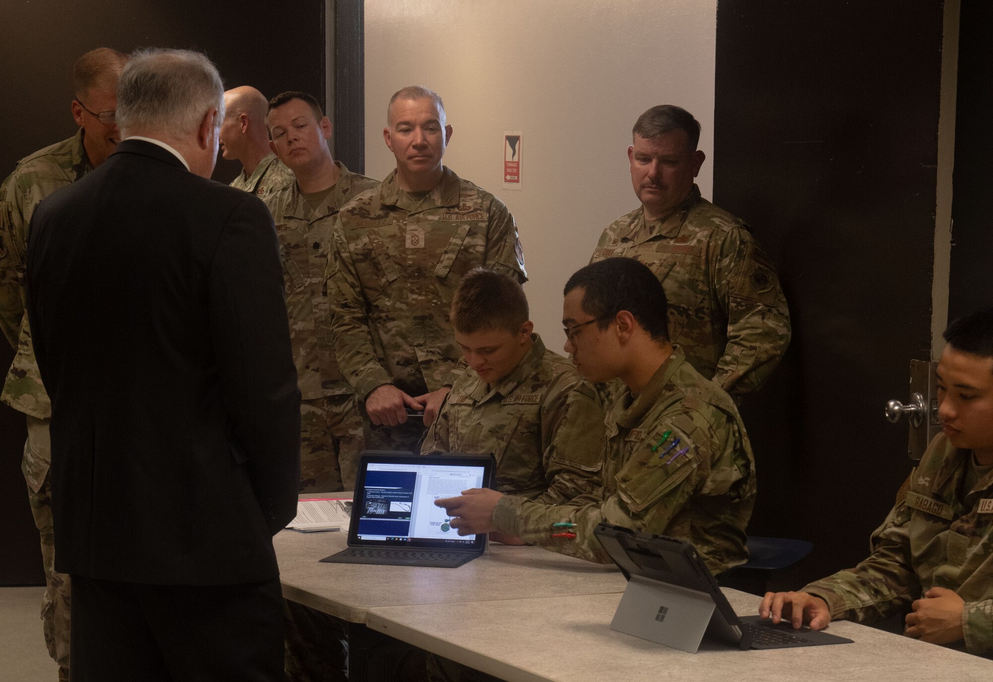 SECAF watches an Airman in Training do school work on a tablet.