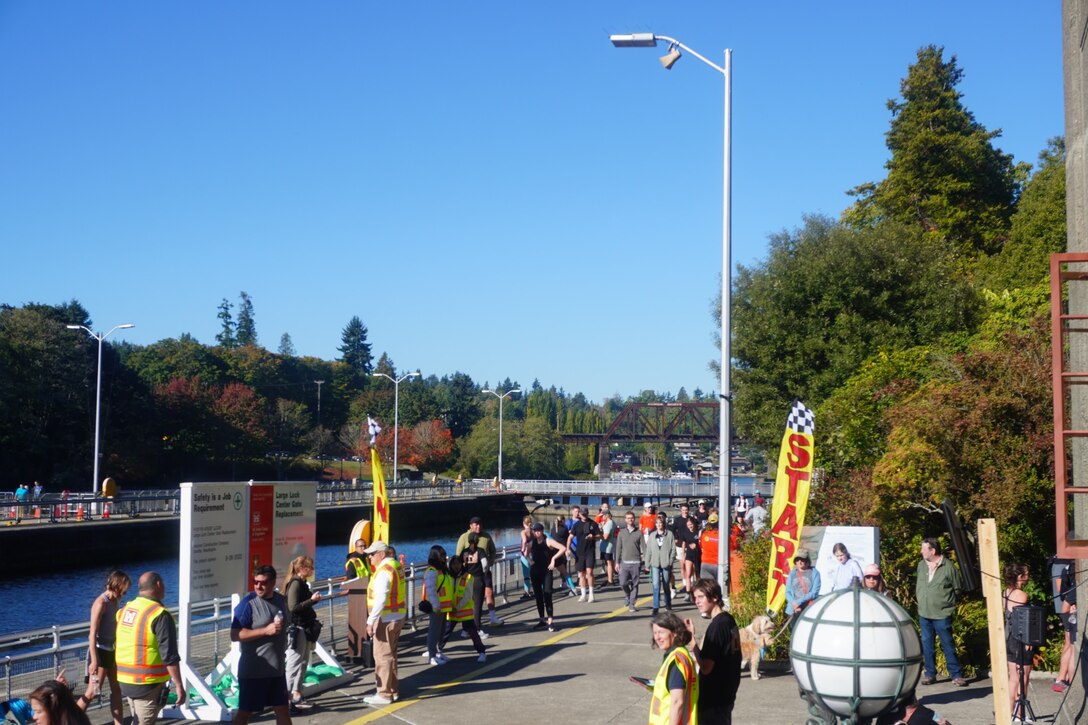 Spectators gather to support participants during the Miter Retire Fun Run at the finish line at Lake Washington Ship Canal and Hiram M. Chittenden Locks, Seattle, Washington.