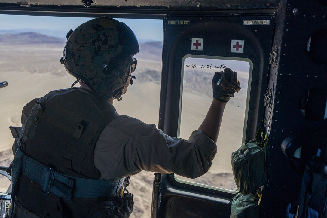 U.S. Marine Corps Staff Sgt. Nicholas Prince, a weapons and tactics instructor with Marine Light Attack Helicopter Squadron (HMLA) 773, 4th Marine Aircraft Wing, Marine Forces Reserve, writes on a window before conducting live fire shooting drills in a UH-1Y Venom Huey during Integrated Training Exercise (ITX) 4-23 at Marine Corps Air Ground Combat Center, Twentynine Palms, California on June 25, 2023. As the Marine Corps Reserve’s premier annual training event, ITX provides opportunities to mobilize geographically dispersed forces for a deployment; increase combat readiness and lethality; and exercise MAGTF command and control of battalions and squadrons across the full spectrum of warfare. Prince is an active duty Marine and native of Victoria, Texas. He graduated from Gila Ridge High School. (U.S. Marine Corps photo by. Cpl. Ryan Schmid)