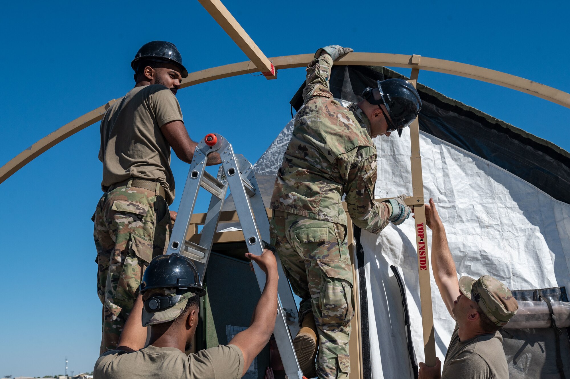 Airmen assemble a tent frame.
