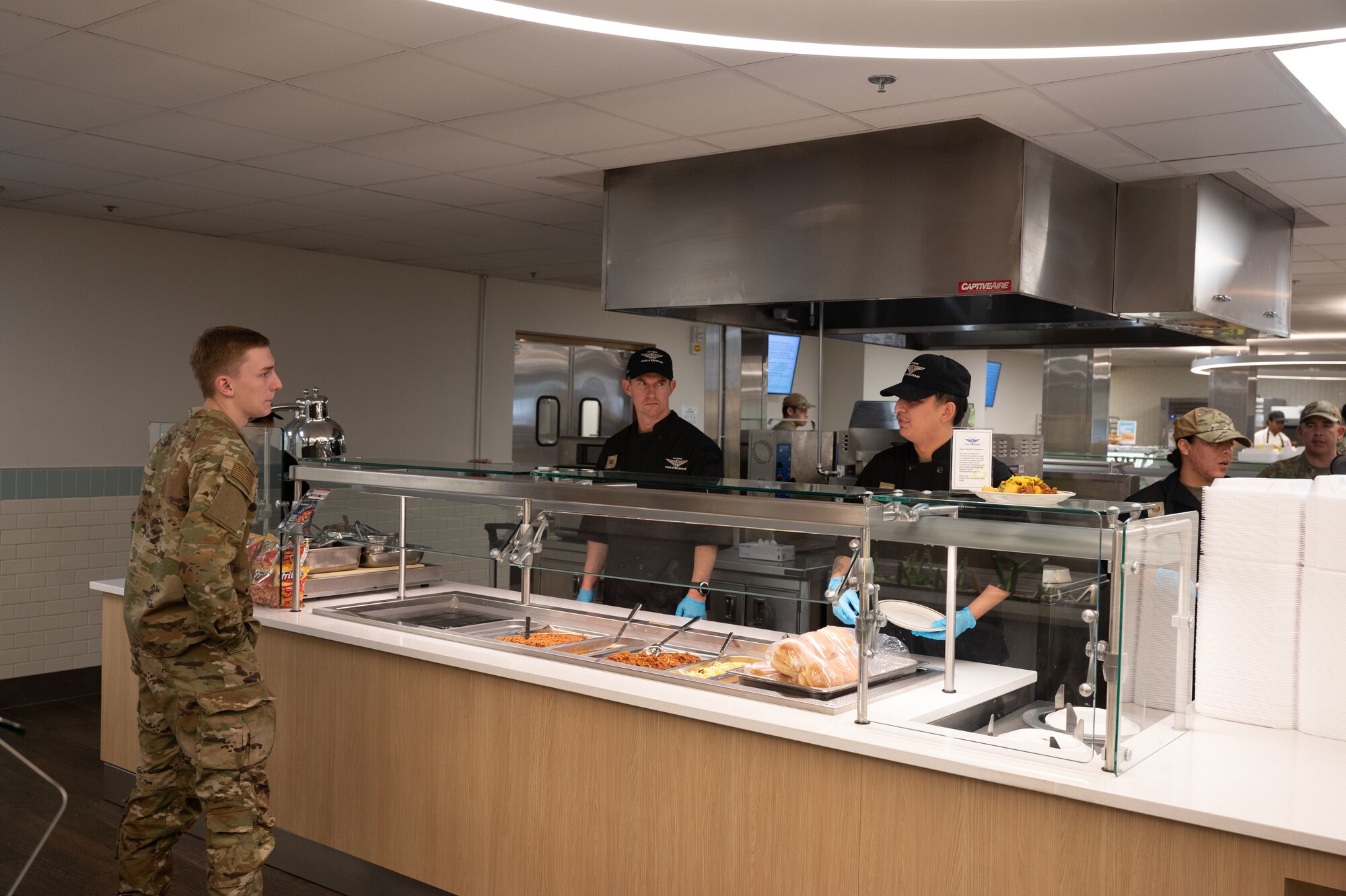 U.S. Air Force Col. Scott Mills, 355th Wing commander, stands with another Airman behind a service counter at Davis-Monthan Air Force Base, Ariz., Oct. 5, 2023. Mills helped Airmen during the ‘Airman For A Day’ event to show thoughtfulness. (U.S. Air Force photo by Airman 1st Class Robert Allen Cooke III)