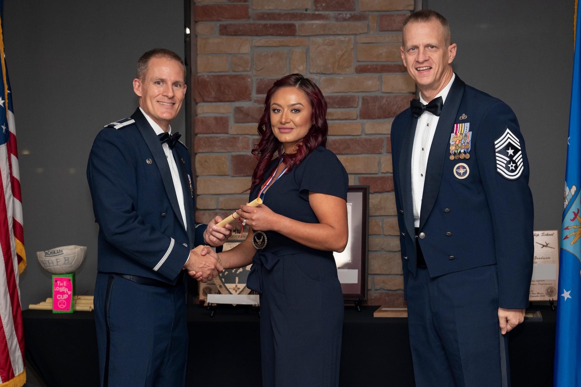 Sandra Maar accepts a graduation certificate from Col. Justin Spears, 49th Wing commander, during a Mayo ALS graduation ceremony.
