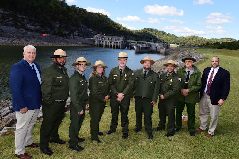 Kenny Claywell (Far Left), Cordell Hull Lake Natural Resource manager; Terrell Stoves, U.S. Army Corps of Engineers Nashville District’s Mid Cumberland Area manager (Far Right); and Retired Park Ranger R. Gerald Lee (Second from Right), pose with all of the current park rangers working during the Cordell Hull Dam 50th Anniversary Celebration Oct. 7, 2023, on the shoreline below the dam in Elmwood, Tennessee. (USACE Photo by Lee Roberts)