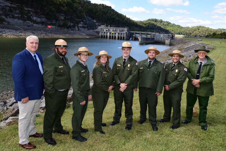 Kenny Claywell (Far Left), Cordell Hull Lake Natural Resource manager, and Retired Park Ranger R. Gerald Lee (Far Right), pose with all of the current park rangers working during the Cordell Hull Dam 50th Anniversary Celebration Oct. 7, 2023, on the shoreline below the dam in Elmwood, Tennessee. (USACE Photo by Lee Roberts)