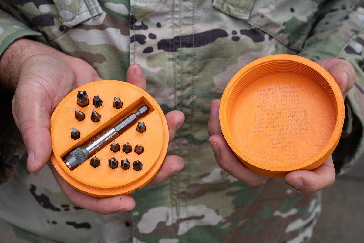 Tech. Sgt. Christopher Saunders, 736th Aircraft Maintenance Squadron home station check dock chief, holds a 3D-printed drill bit case at Dover Air Force Base, Delaware, Sept. 29, 2023. Saunders, a former Bedrock Innovation Lab intern, updated the drill bit case to include extra storage compartments for bits, embedded magnets and stronger materials. These new features increased efficiency and durability and will, over time, decrease cost. (U.S. Air Force photo by Senior Airman Cydney Lee)