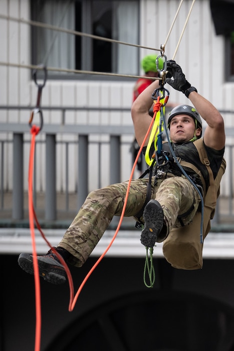 A U.S. Air Force pararescueman executes an urban high-angle ropes scenario to reach a simulated injured service member, render medical care, and lower him to safety during the 2023 PJ Rodeo competition in Louisville, Ky., Sept. 6, 2023. The biennial event, which tests the capabilities of pararescue Airmen across the service, was hosted by the Kentucky Air National Guard’s 123rd Special Tactics Squadron. (U.S. Air National Guard photo by Dale Greer)