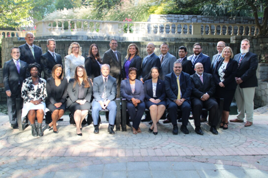 Group of professionally dressed workers posing for photo.