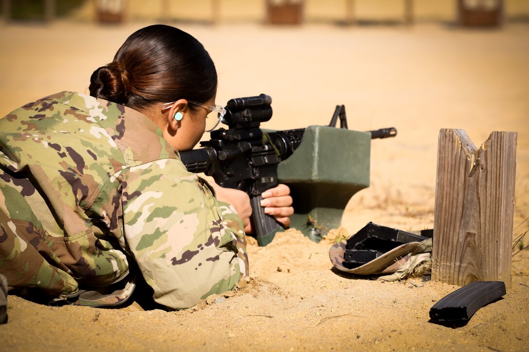 A soldier in a prone position fires a weapon during training.