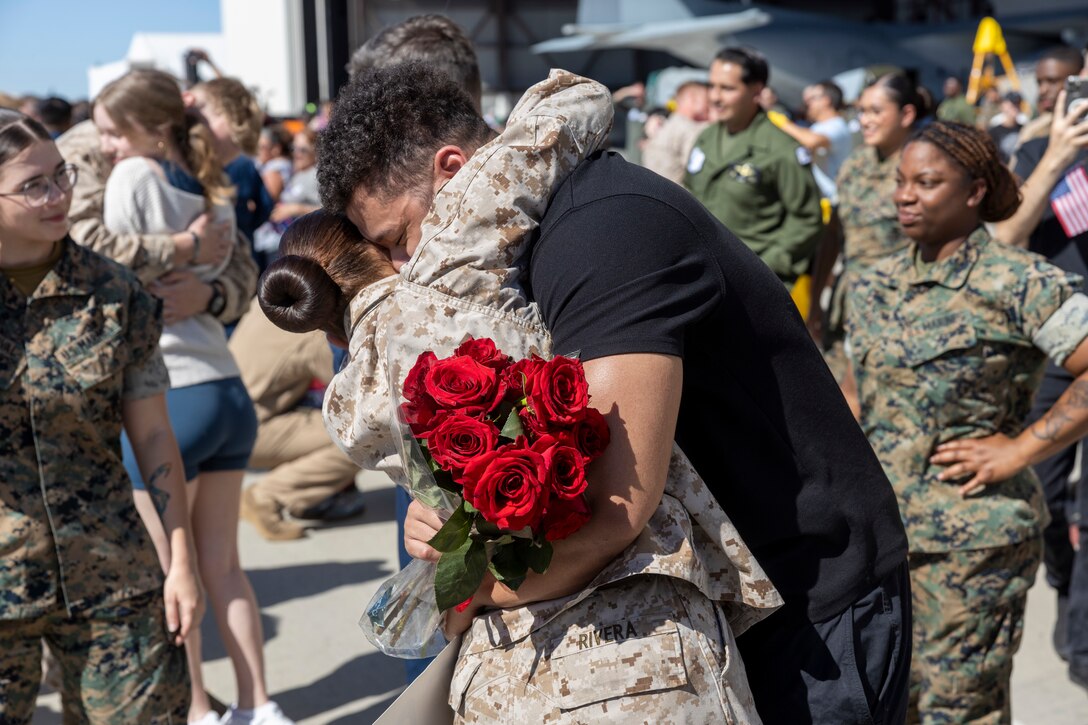 A U.S. Marine with Marine Aerial Refueler Transport Squadron (VMGR) 352, Marine Aircraft Group 11, 3rd Marine Aircraft Wing, embraces her spouse upon returning home from deployment at Marine Corps Air Station Miramar, Oct. 6, 2023. Marines with VMGR-352 returned from deployment supporting Special Purpose Marine Air-Ground Task Force Crisis Response Africa, a self-mobile crisis response force that conducts theater security cooperation and contingency missions.  (U.S. Marine Corps photo by Cpl. Daniel Childs)