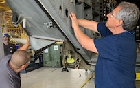 Man works on aircraft.
