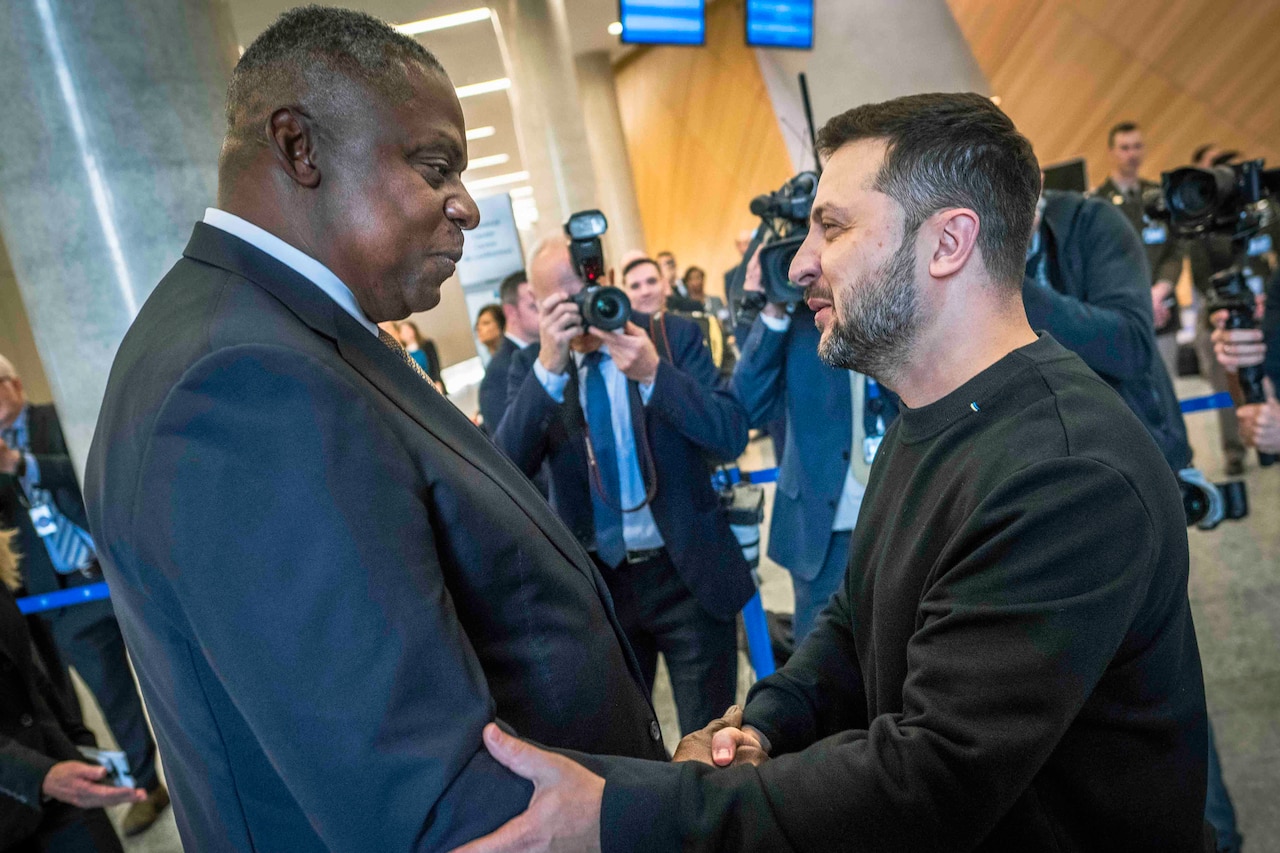 Two men shake hands.