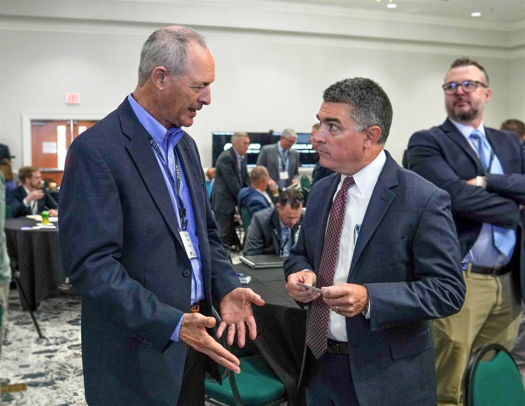 IMAGE: Naval Surface Warfare Center Dahlgren Division Technical Director Dale Sisson Jr., SES, engages in a discussion about exploring avenues to enhance naval defenses with an attendee of the Naval Surface Technology & Innovation Consortium Other Transaction Authority Collaboration Event, Oct. 4.