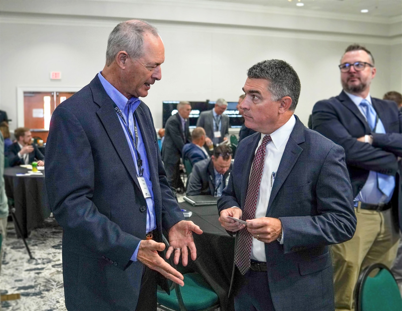 IMAGE: Naval Surface Warfare Center Dahlgren Division Technical Director Dale Sisson Jr., SES, engages in a discussion about exploring avenues to enhance naval defenses with an attendee of the Naval Surface Technology & Innovation Consortium Other Transaction Authority Collaboration Event, Oct. 4.