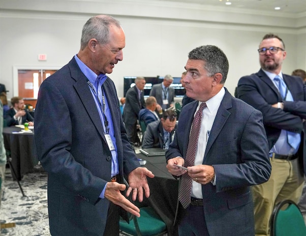 IMAGE: Naval Surface Warfare Center Dahlgren Division Technical Director Dale Sisson Jr., SES, engages in a discussion about exploring avenues to enhance naval defenses with an attendee of the Naval Surface Technology & Innovation Consortium Other Transaction Authority Collaboration Event, Oct. 4.