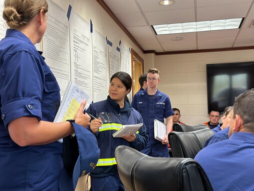 Lt. j.g. Deb King leads an incident management team meeting at U.S. Coast Guard Forces Micronesia/Sector Guam on Oct. 11, 2023, as the assembled team discusses steps to address the impacts of Typhoon Bolaven. The group included members of FM/SG, Base Guam, DOL-X, USCGC Hickory (WLB 212), and U.S. Coast Guard District 14. (U.S. Coast Guard photo by Chief Warrant Officer Sara Muir)