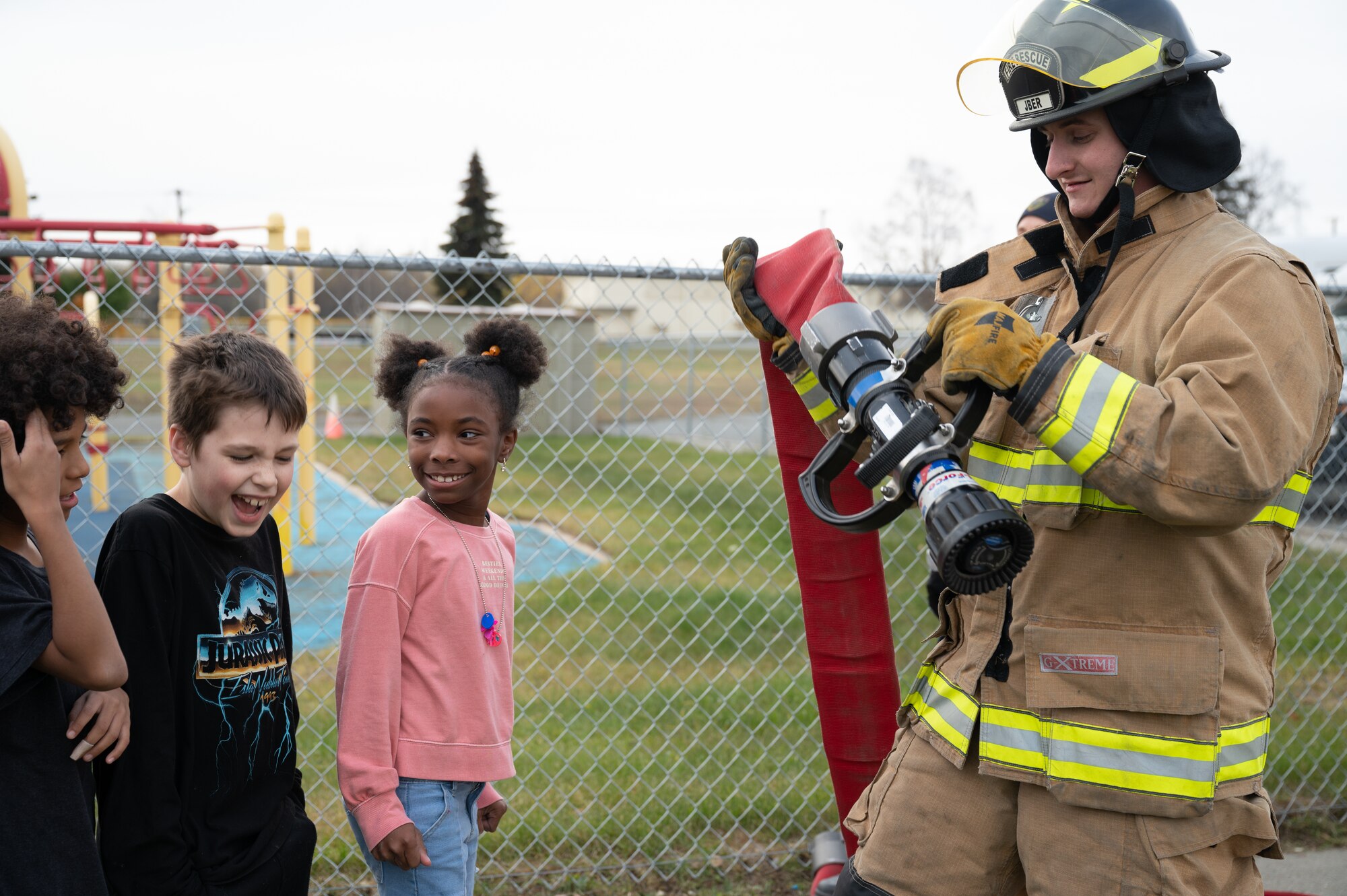 Children line up with firefighter.