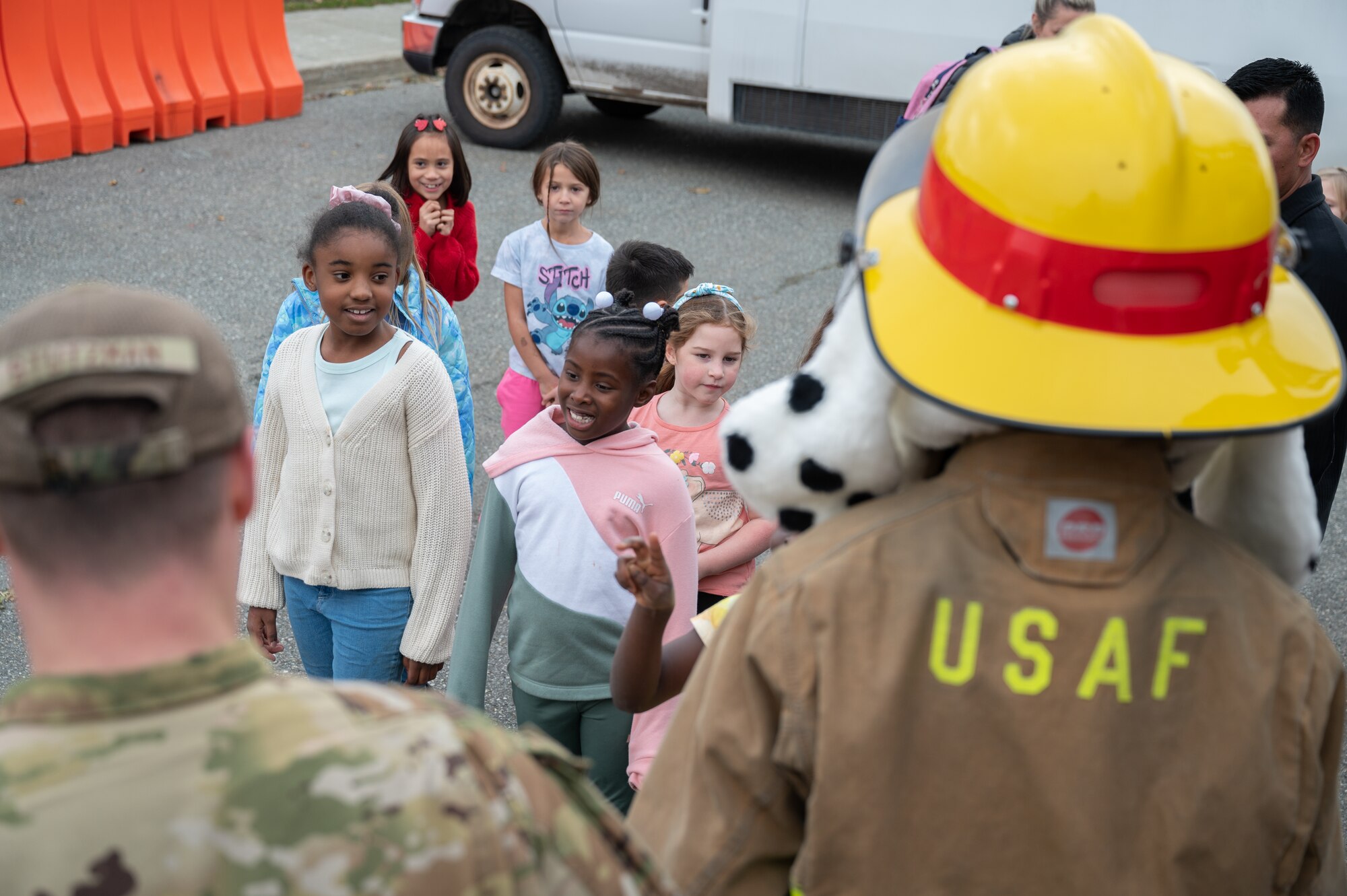 Children pose with  Sparky, the 673d Civil Engineer Squadron fire dog mascot