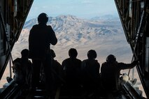 U.S. Air Force Airmen from the 34th Weapons Squadron gaze out the back of a C-130J Combat King II over Las Vegas, Nevada, Oct. 9, 2023.
