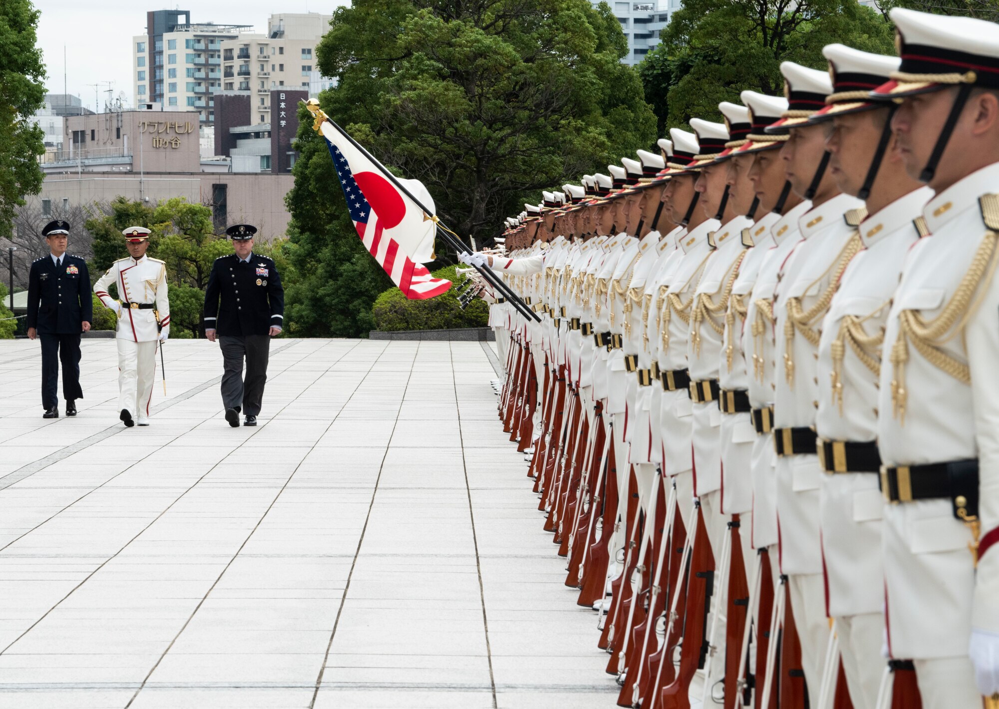 People walking while next to a formation for a ceremony.