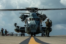 U.S. Marine Corps Lance Cpl. Braden Asaro, a crew chief with Heavy Helicopter Squadron 462, Marine Aircraft Group 16, 3rd Marine Aircraft Wing, gives hand and arm signals during a familiarization flight in support of Marines with 3rd Maintenance Battalion, 3rd Marine Logistics Group, at Marine Corps Air Station Futenma, Okinawa, Japan, Sept. 26, 2023. The purpose of a familiarization flight is to help Marines refine the necessary processes and procedures for assault support in preparation of pre-deployment training. (U.S. Marine Corps photo by Lance Cpl. Jessi Stegall)