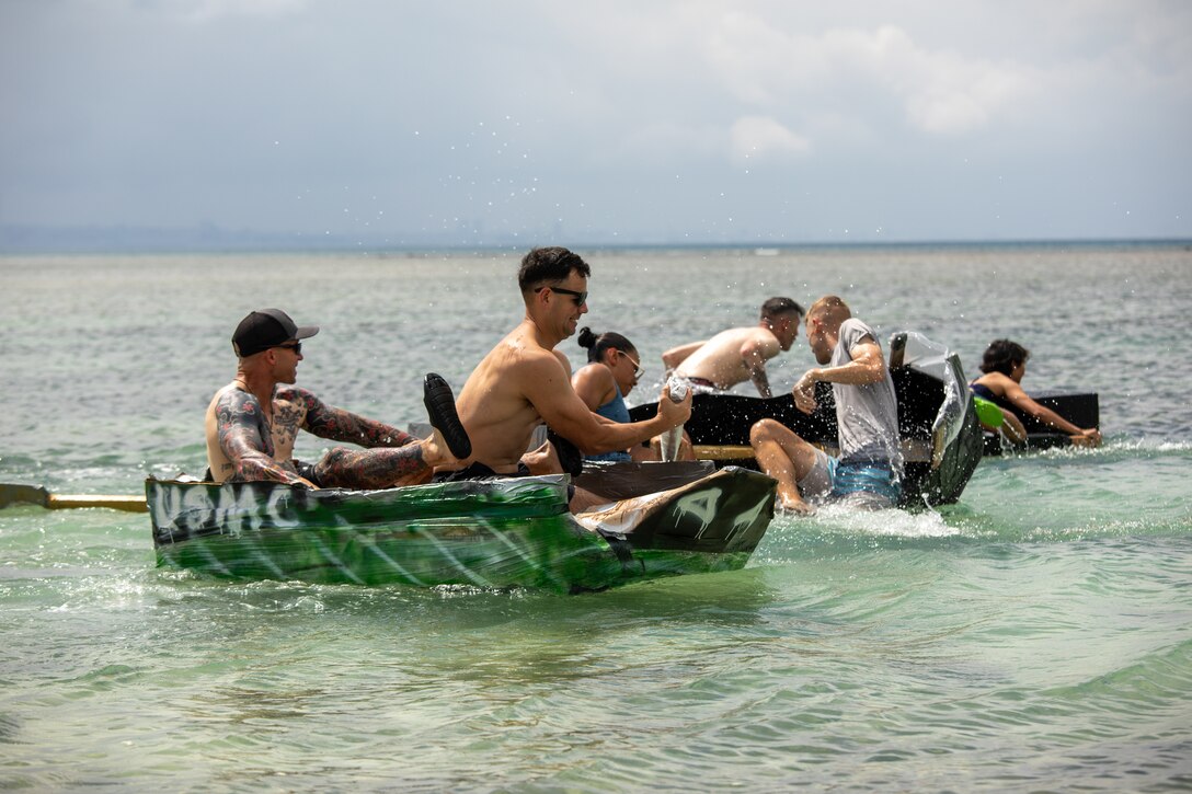 U.S. Marines with Combat Logistics Regiment 37, 3rd Marine Logistics Group, race cardboard boats during a beach bash at Torii Beach, Okinawa, Japan, Sept. 29, 2023. The purpose of the beach bash was to increase morale and build comradery amongst fellow Marines. (U.S. Marine Corps Photo by Lance Cpl. Jessi Stegall)