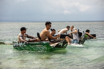 U.S. Marines with Combat Logistics Regiment 37, 3rd Marine Logistics Group, race cardboard boats during a beach bash at Torii Beach, Okinawa, Japan, Sept. 29, 2023. The purpose of the beach bash was to increase morale and build comradery amongst fellow Marines. (U.S. Marine Corps Photo by Lance Cpl. Jessi Stegall)