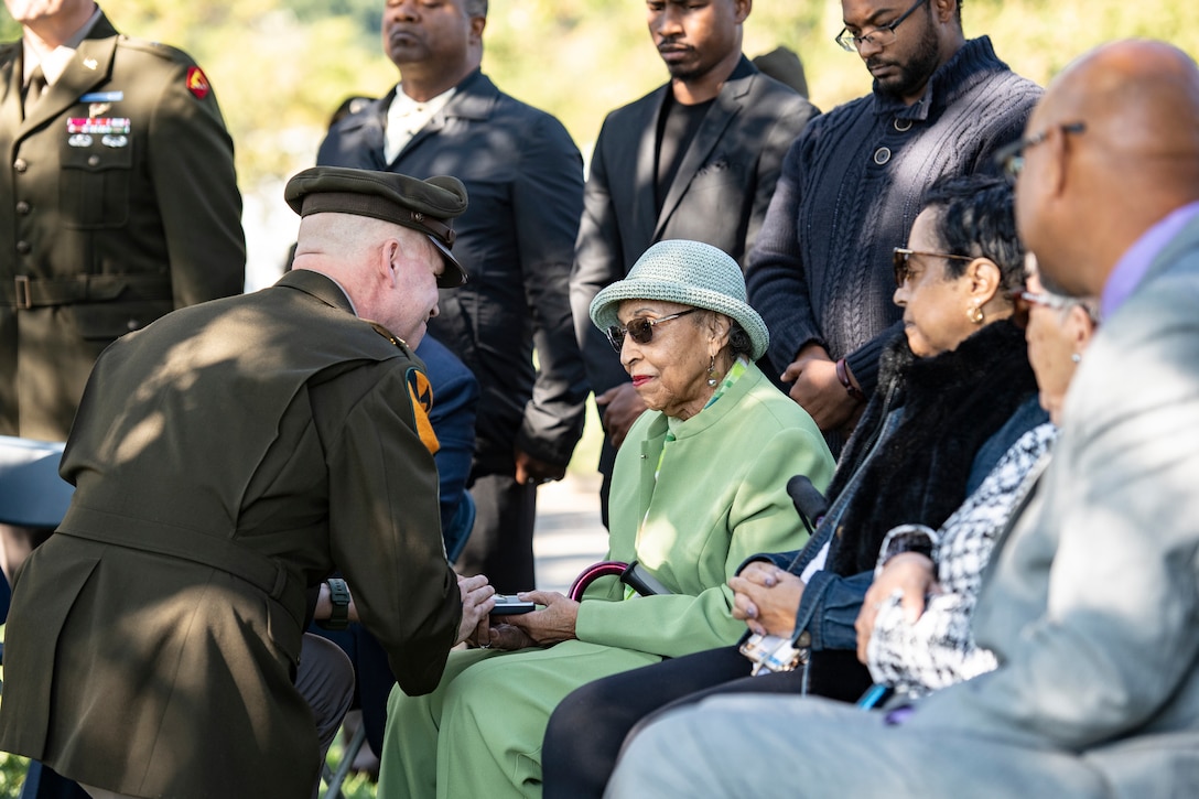 A military officer presents a medal to a civilian during  a ceremony.