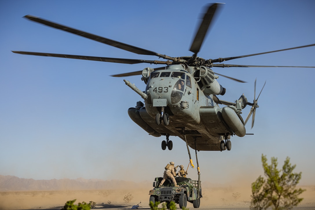 U.S. Marines assigned to Marine Aviation Weapons and Tactics Squadron One, attach a High Mobility Multipurpose Wheeled Vehicle to a CH-53E Super Stallion helicopter during Weapons and Tactics Instructor course 1-24 at Auxiliary Airfield II. near Yuma, Arizona, Oct. 3, 2023. WTI is an advanced, graduate-level course for selected pilots and enlisted aircrew providing standardized advanced tactical training and assists in developing and employing aviation weapons and tactics.