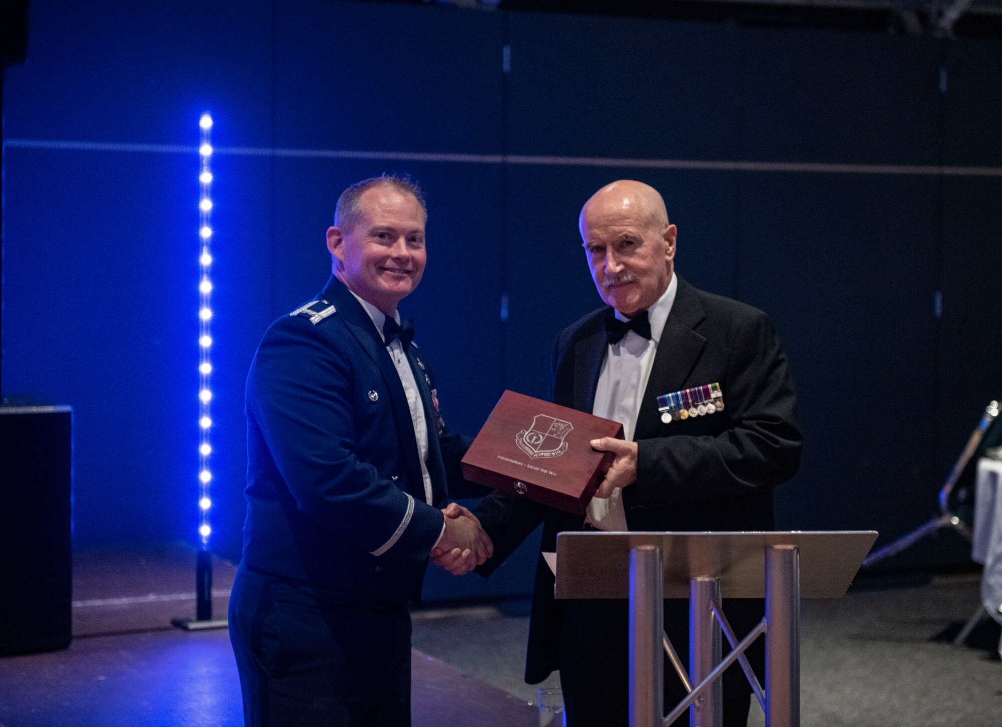 Col. D. Landon Phillips, 501st Combat Support Wing commander, left, presents an award to Warrant Officer 1st Class (RET) John Martin O’Kelly at Sywell Aerodrome