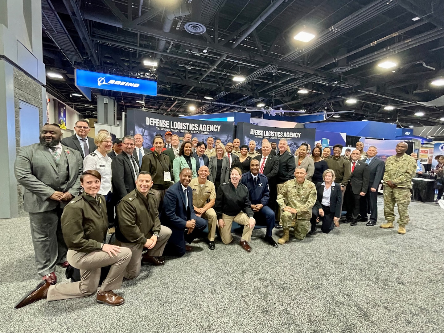 A large group of people gather in a crowd and pose for a photo.