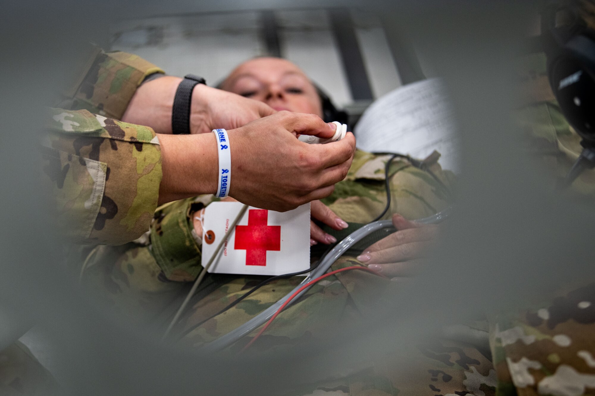 A simulated patient has a pulse oximeter put on their finger to measure oxygen saturation levels