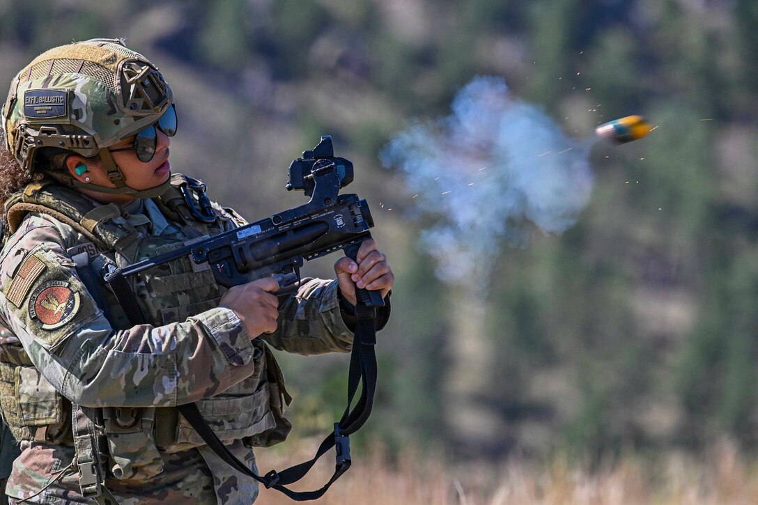 An airman fires a grenade launcher.