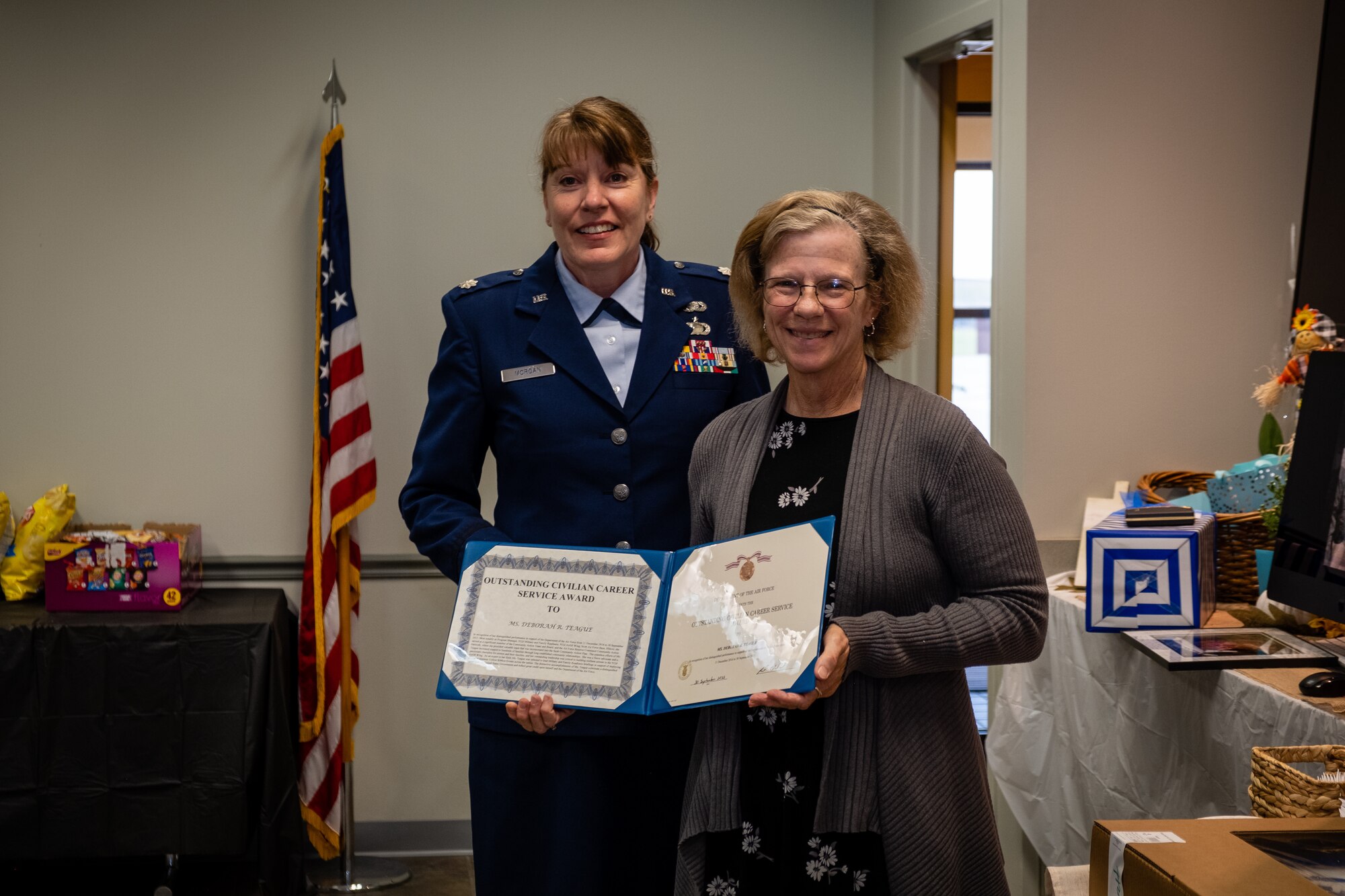Lt. Col. Amy Morgan, 932nd Airlift Wing Missions Support Group deputy commander, presents Deb Teague, 932nd Military and Family Readiness Center program manager with the Outstanding Civilian Career Service Award, Sept. 29, 2023, Scott Air Force Base, Illinois. Deb recently closed her Air Force career, which originated from active duty military service at the age of 19. (U.S. Air Force photo by Christopher Parr)
