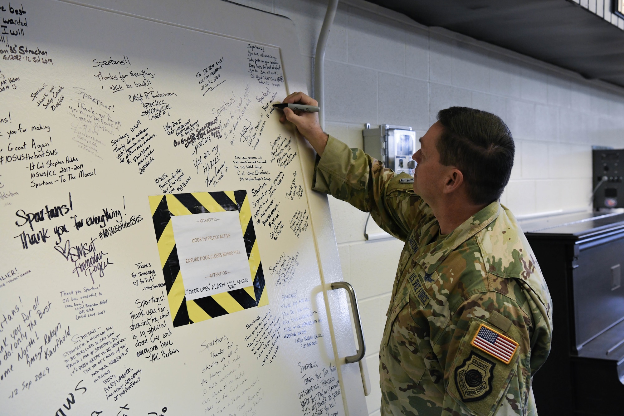 Military member signs a large door.