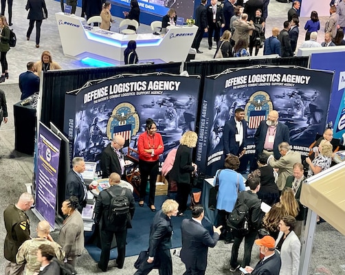 Photo of people at a convention booth from above the convention center floor.