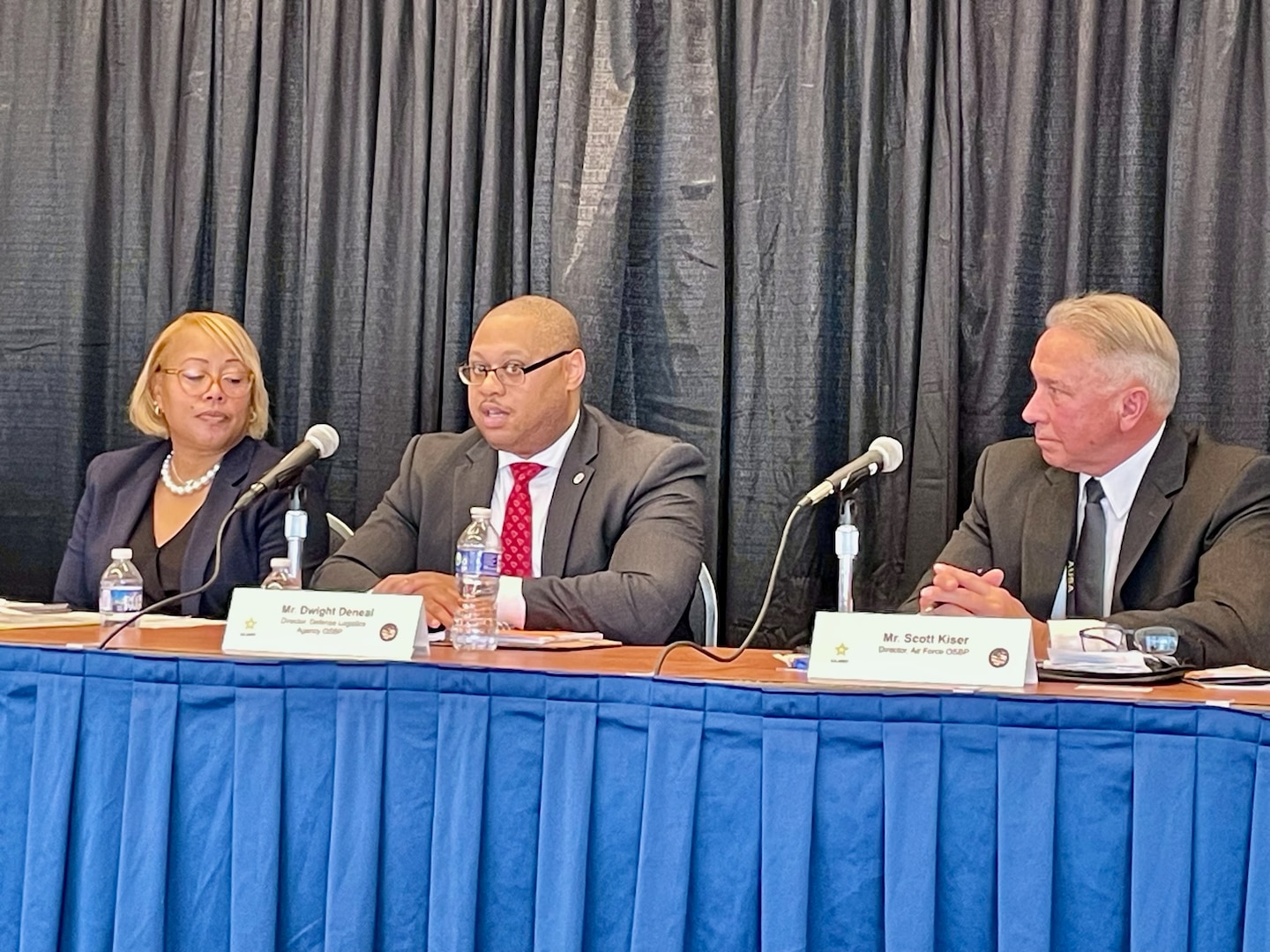 Three people sit at a table as part of a panel discussion.