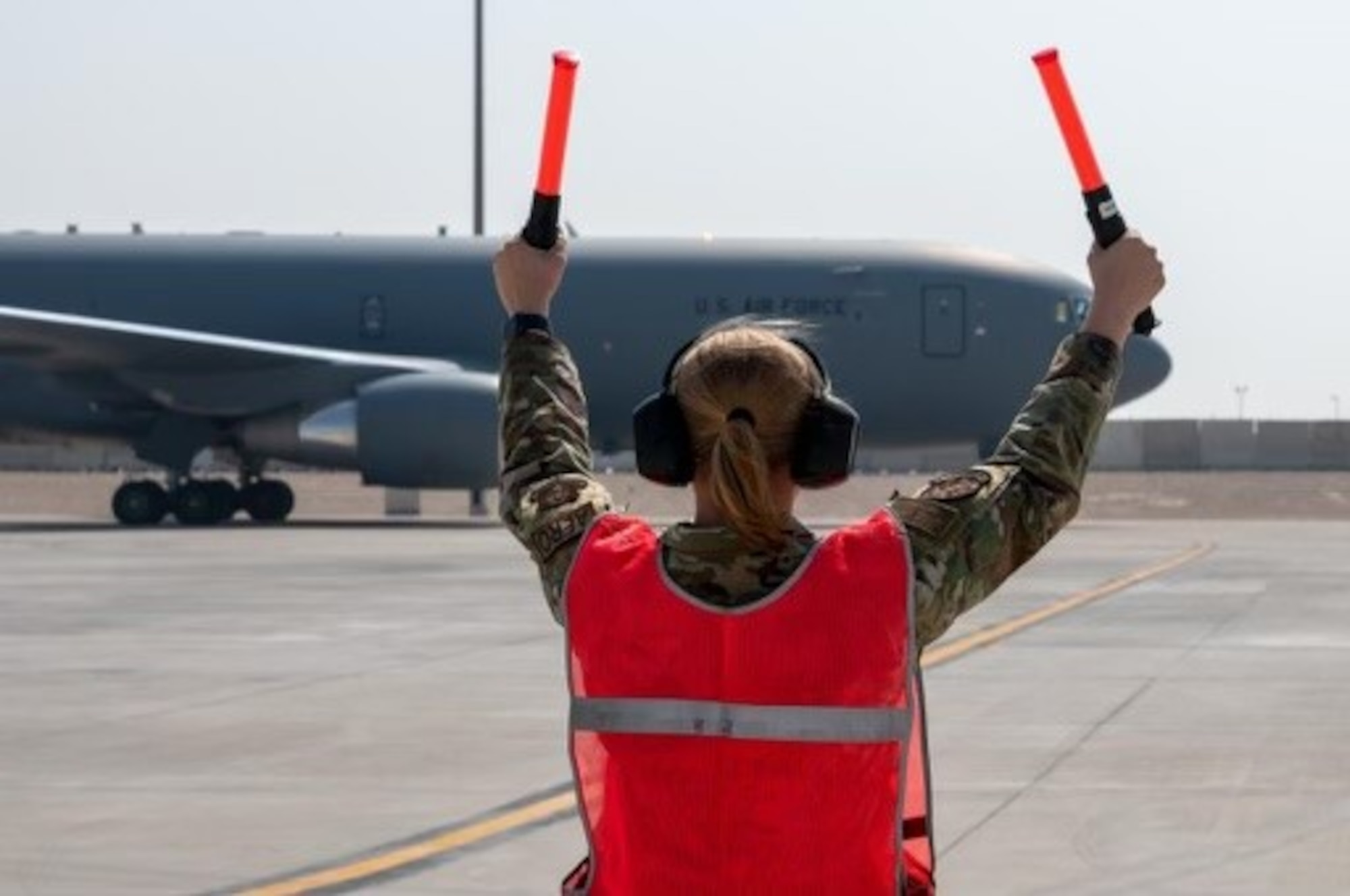 Image of Senior Airman Abigail Sherbondy, 931st Maintenance Squadron reclamation journey man, marshalling aircraft at McConnell Air Force Base, Kansas.