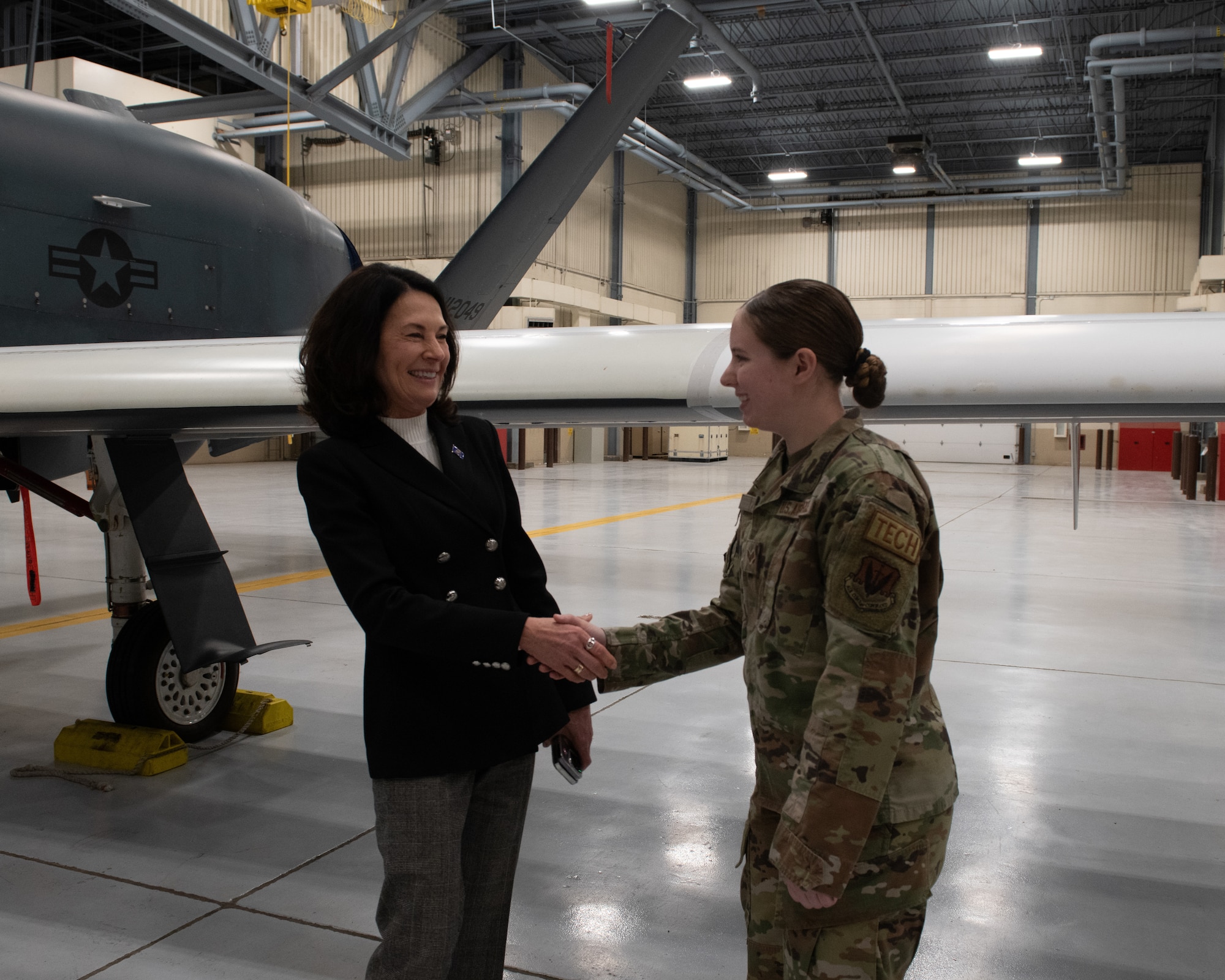 Woman shakes hand with Airman.