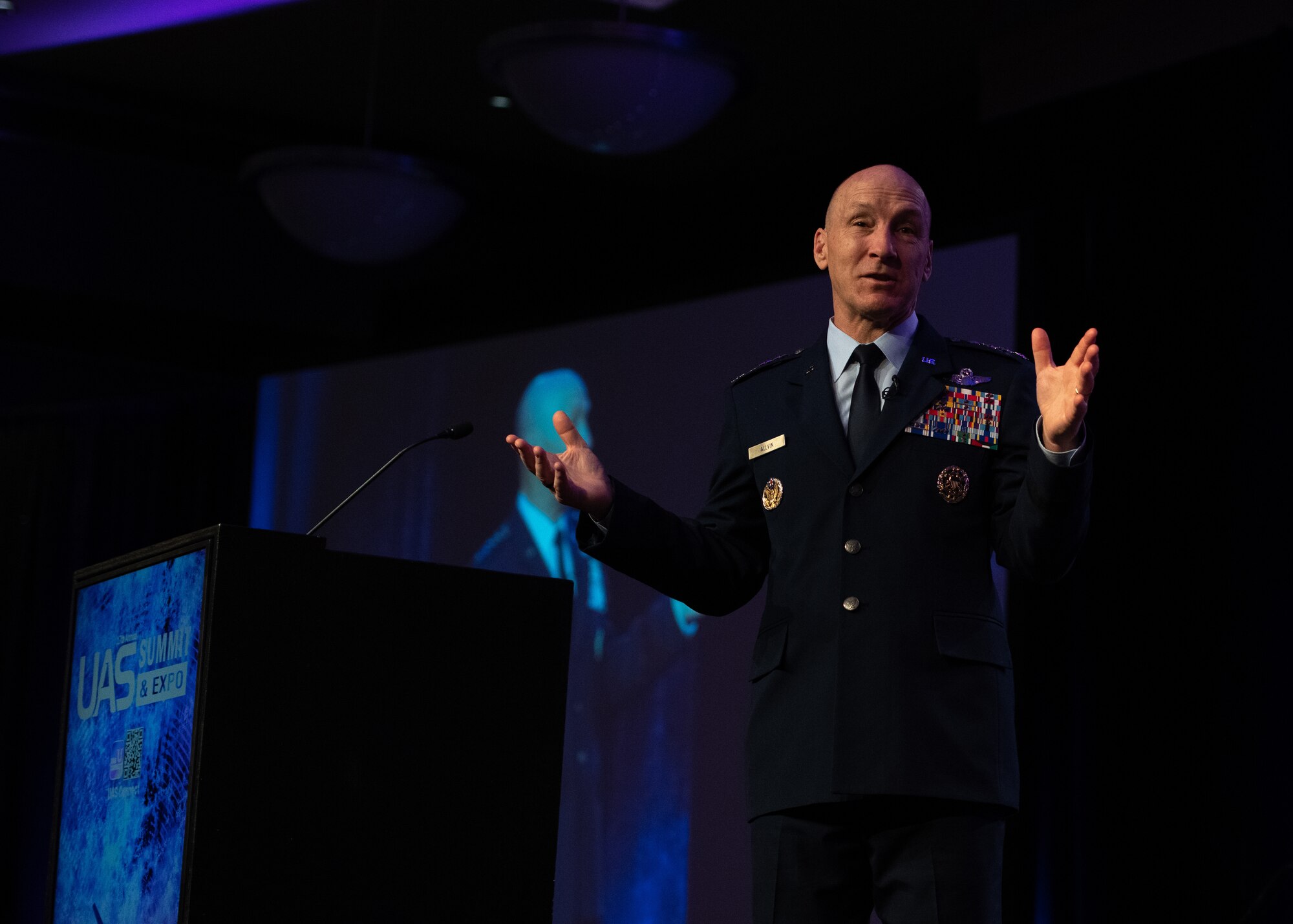 Man Speaking with arms up.