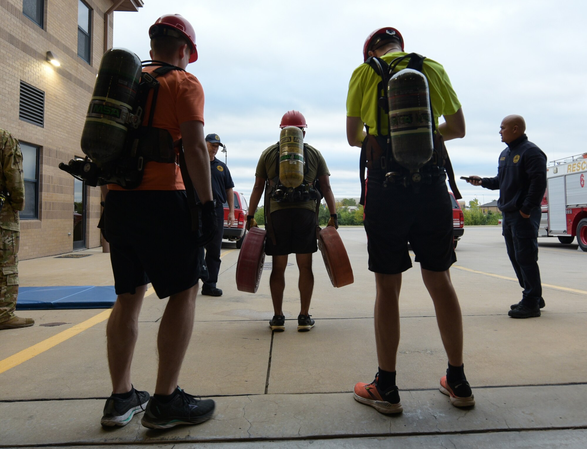 An Airman from the 22nd Civil Engineer Squadron prepares to speed walk with two fire hoses during the annual 22nd CES Fire Muster Oct. 12, 2023, at McConnell Air Force Base, Kansas. The Fire Muster consisted of five teams competing for the fastest time to complete various tasks such as climbing a ladder, unrolling a large fire hose, dragging a dummy and spraying a fire hose at a target. (U.S. Air Force photo by Staff Sgt. Tryphena Mayhugh)