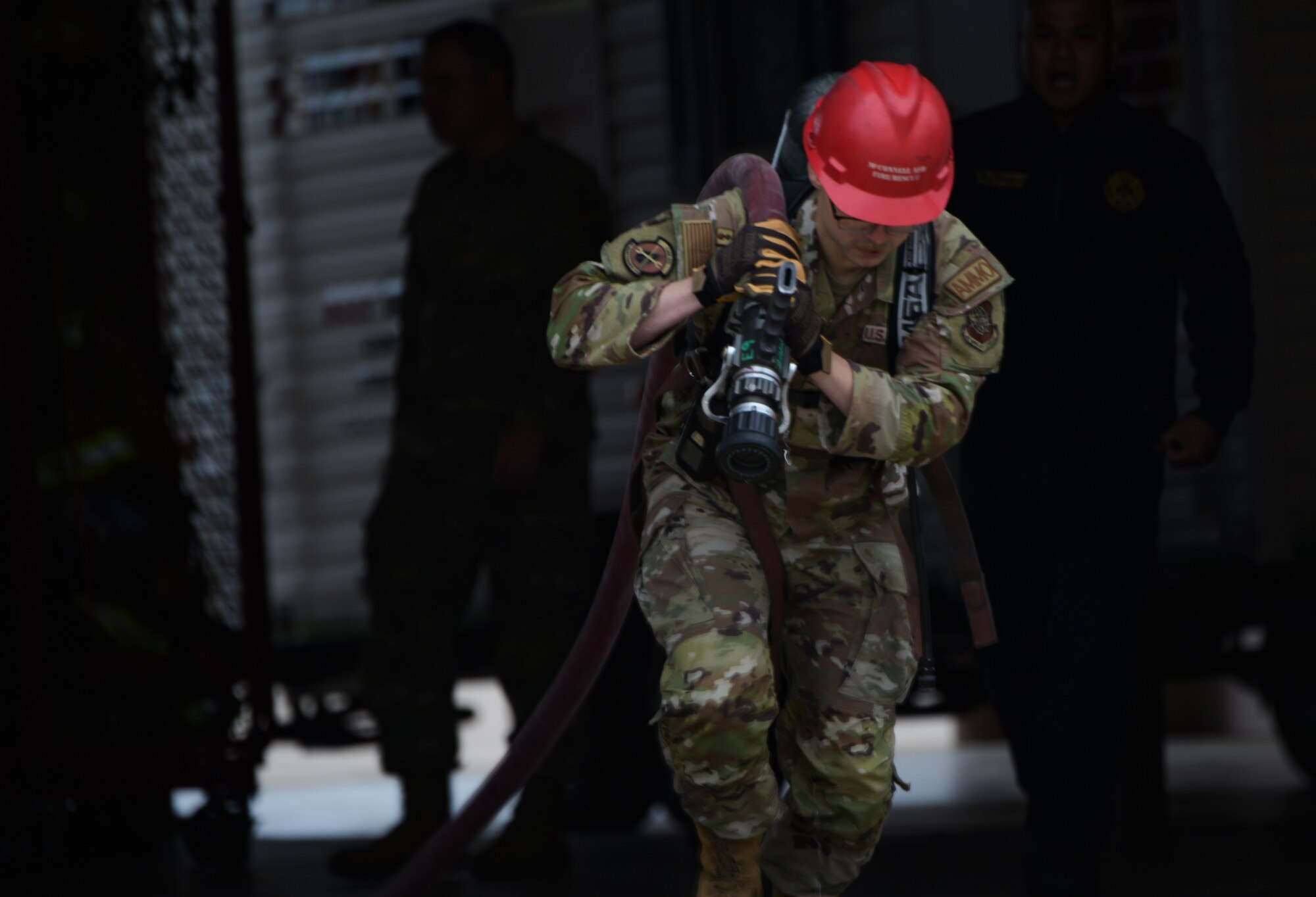 An Airman from the 22nd Munitions Squadron drags a fire hose during the annual 22nd Civil Engineer Squadron Fire Muster Oct. 12, 2023, at McConnell Air Force Base, Kansas. The Fire Muster consisted of five teams competing for the fastest time to complete various tasks such as climbing a ladder, unrolling a large fire hose, dragging a dummy and spraying a fire hose at a target. (U.S. Air Force photo by Staff Sgt. Tryphena Mayhugh)