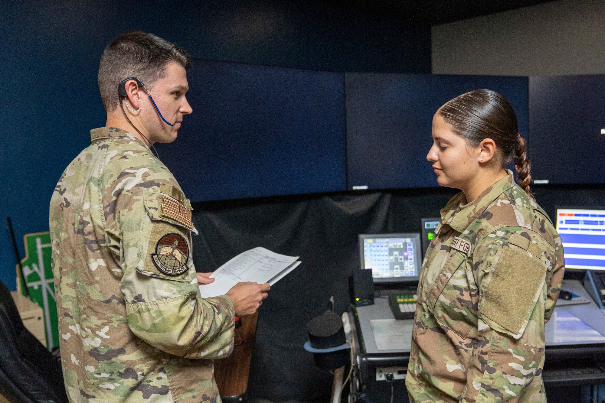 U.S. Air Force Staff Sgt. Michael Russell, 334th Training Squadron air traffic control instructor, reviews a student's performance on their daily practical assessment at Keesler Air Force Base, Mississippi, Sept. 26, 2023.