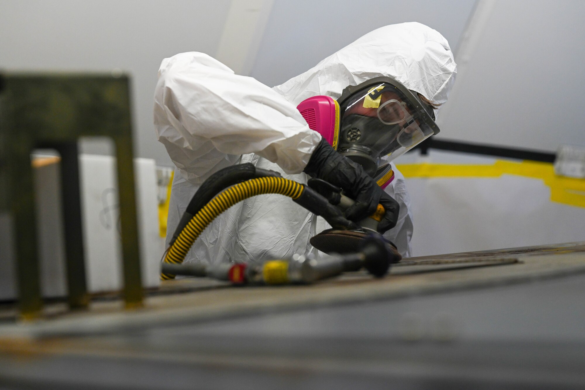 Airman 1st Class Tyler Edwards, 15th Maintenance Squadron aircraft structural maintenance journeyman, sands a corroded hydraulic cart in preparation for repair in a new mobile paint booth at Joint Base Pearl Harbor-Hickam, Hawaii, Oct. 11, 2023. The mobile paint booth is a modular, customizable and deployable shelter that allows Airmen the capabilities to maintain and improve equipment in any environment. (U.S. Air Force photo by Senior Airman Makensie Cooper)