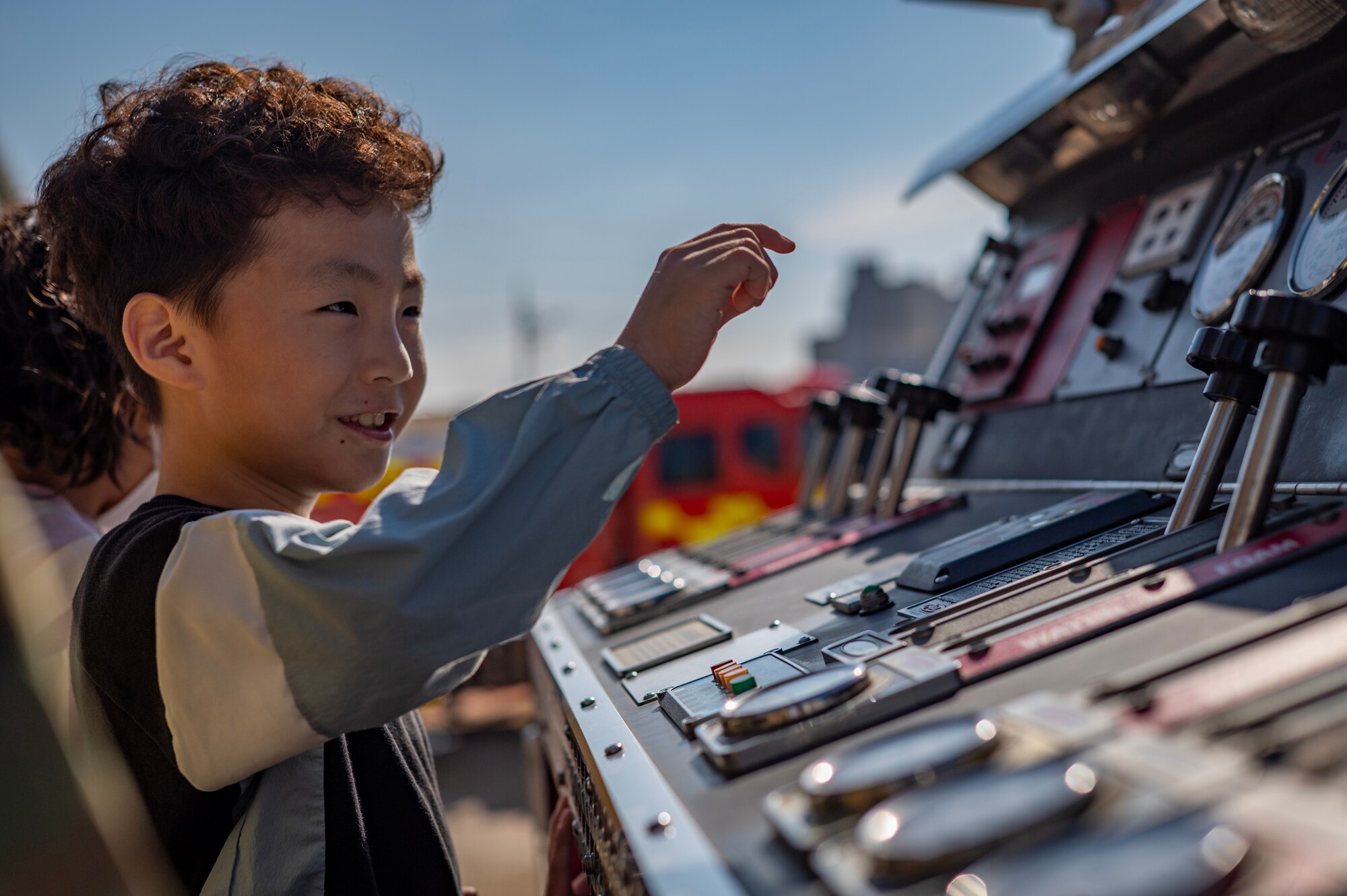 A child from Gunsan Jigok Elementary School explores the functions of a fire truck during a Fire Prevention Week education event hosted by the 8th Civil Engineer Squadron.